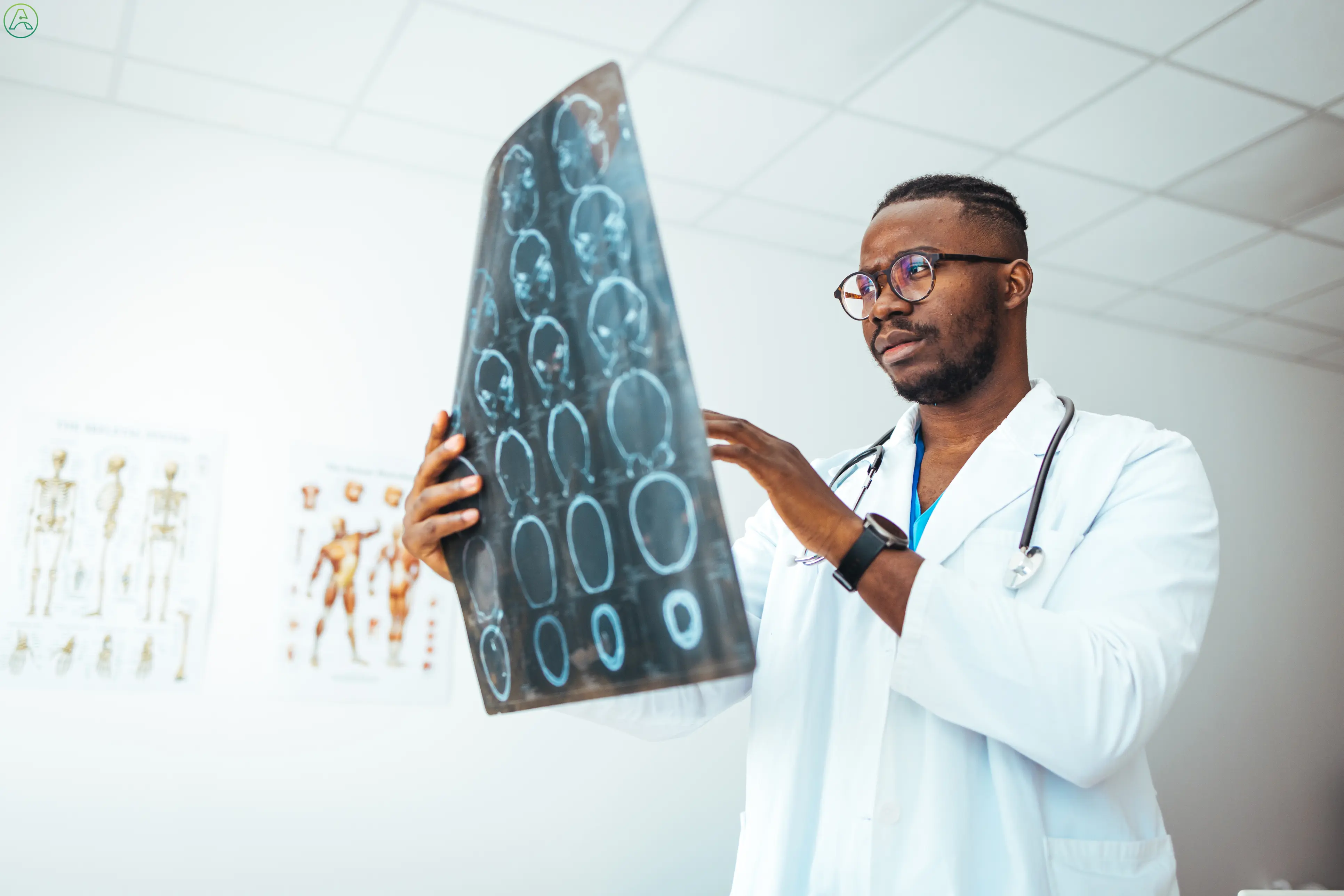 Black doctor examines x-rays of spine.