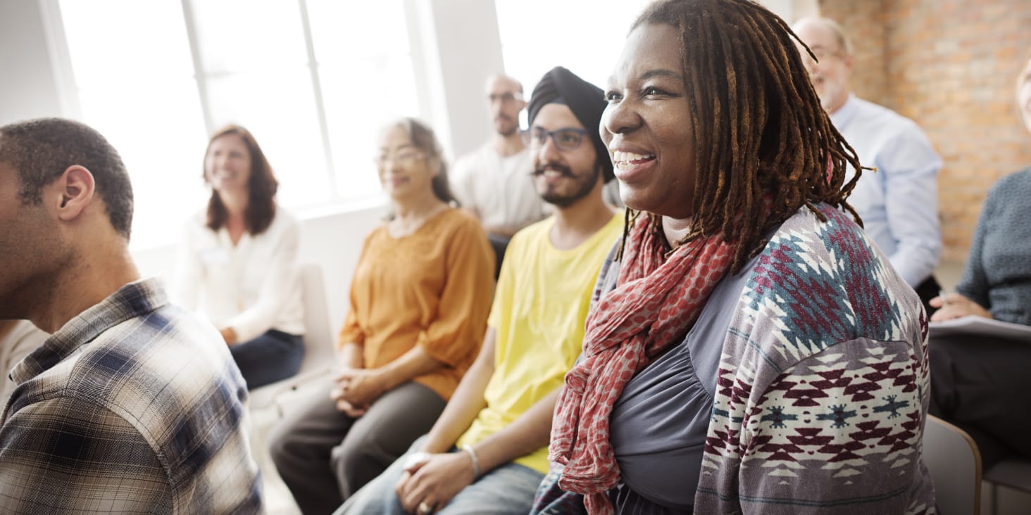 diverse group of adults attends an in-person community meeting
