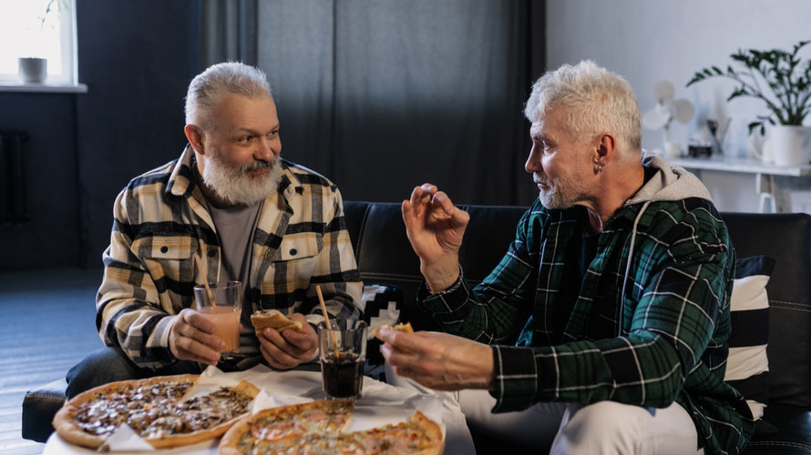 Two senior men having  fun dinner