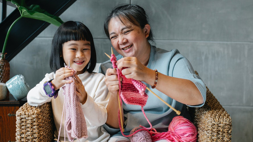 Senior teaching someone how to knit