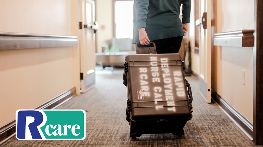 nurse with a large wheeled box going down hallway of assistive living home