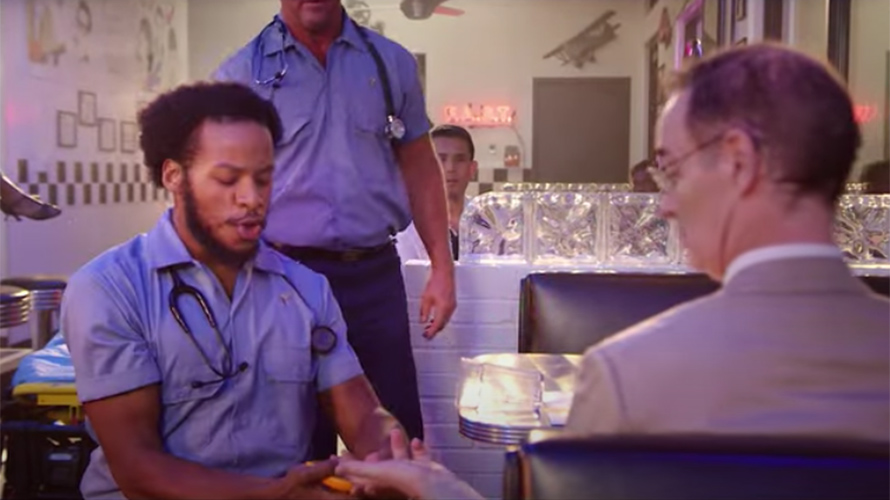 Screenshot from video with EMTs helping a stroke victim in a restaurant