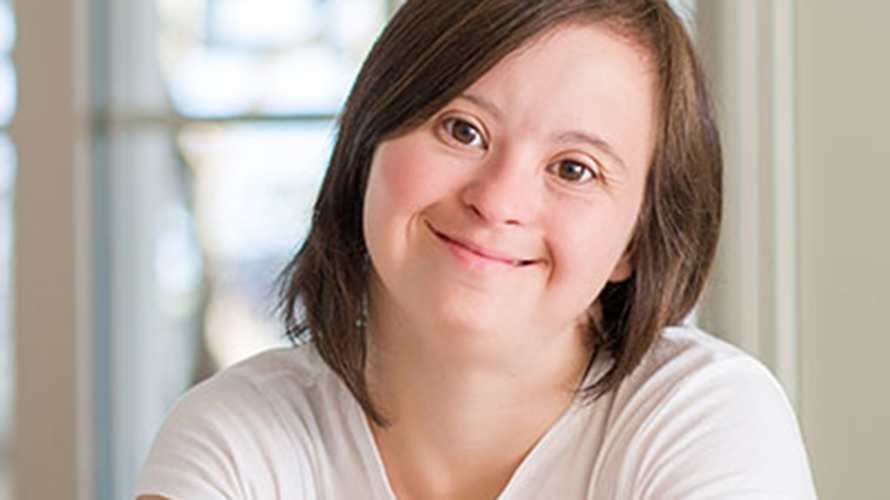 Teen with Down Syndrome smiling with crossed arms