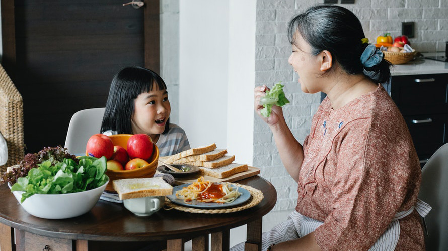 Older lady eating healthy food with grandchild