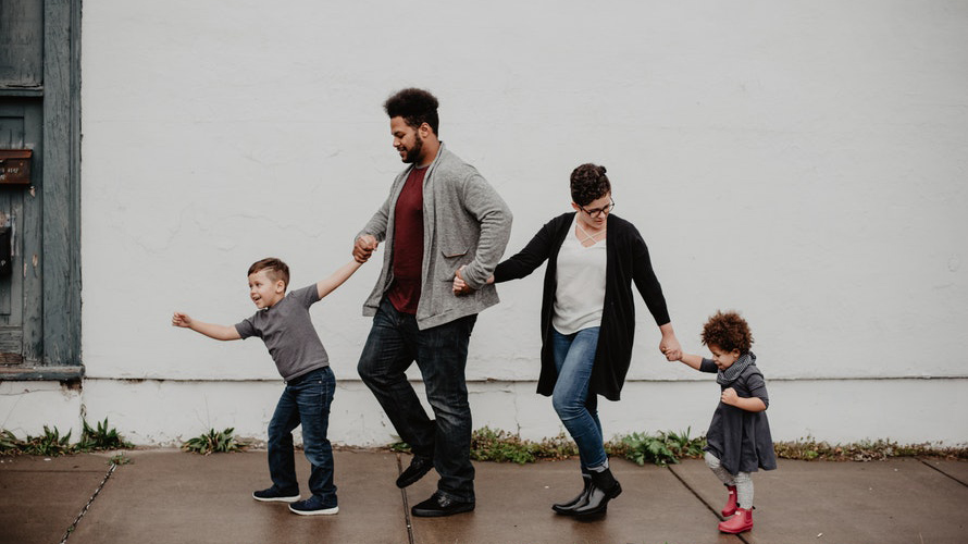 Parents and children walking in a line holding hands