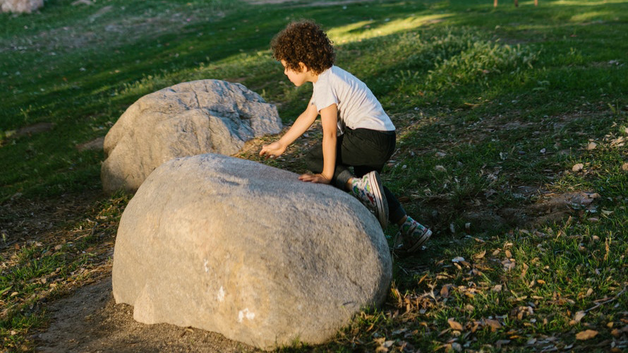 Boy climbing rock in a park